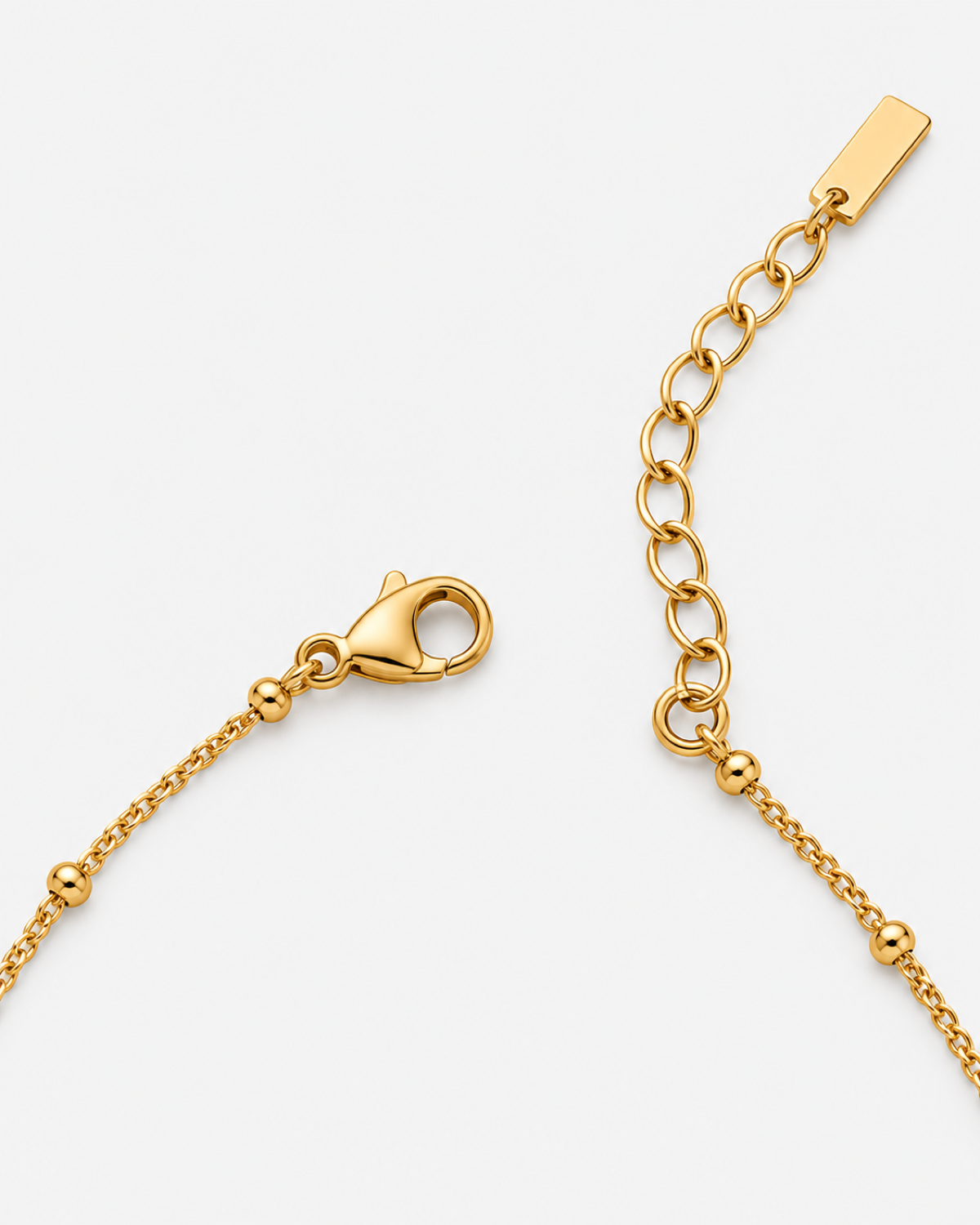 Gold-tone necklace clasp, extender and round bead stations shown in detail