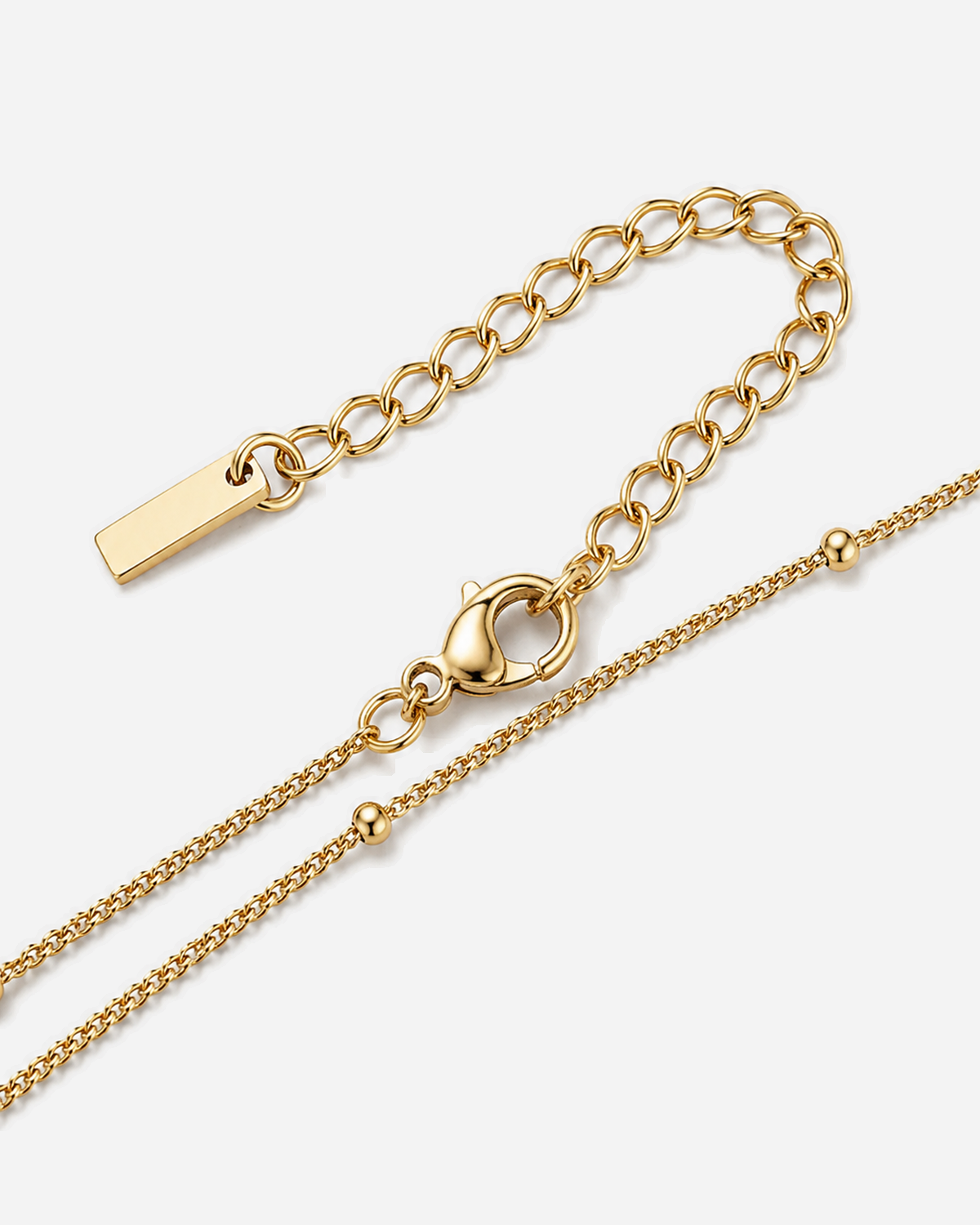 Isolde Cross Necklace — 09 — Gold — dark-teal/shell-pink one-shoulder outfit — plain unbranded clasp/extender construction macro