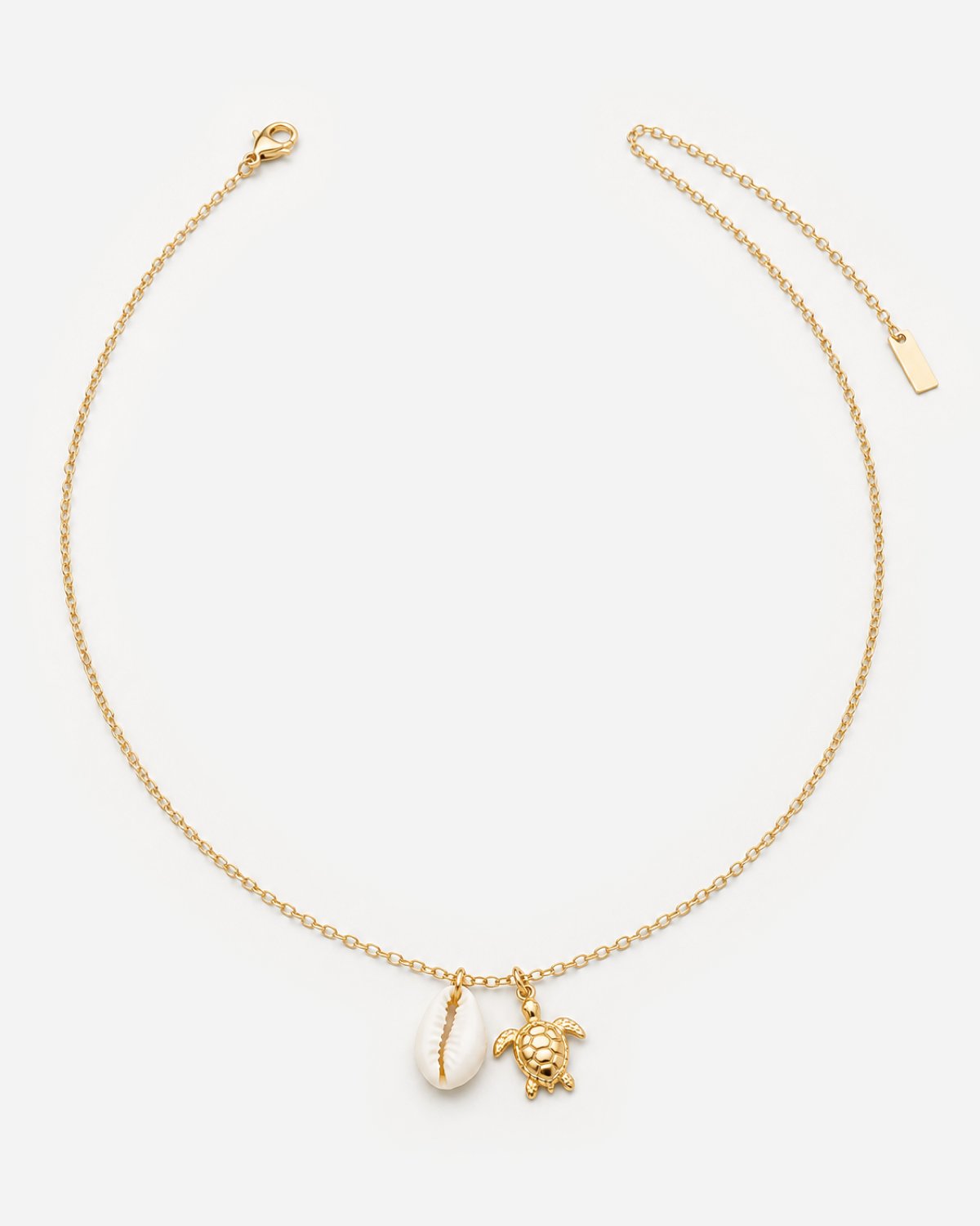 Malia gold-tone necklace with white shell-shaped and textured turtle charms.
