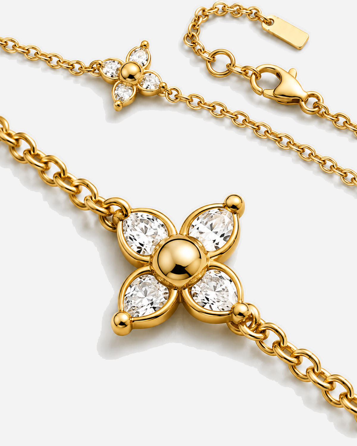 Katia gold-tone quatrefoil motifs with clear accents and connecting chain