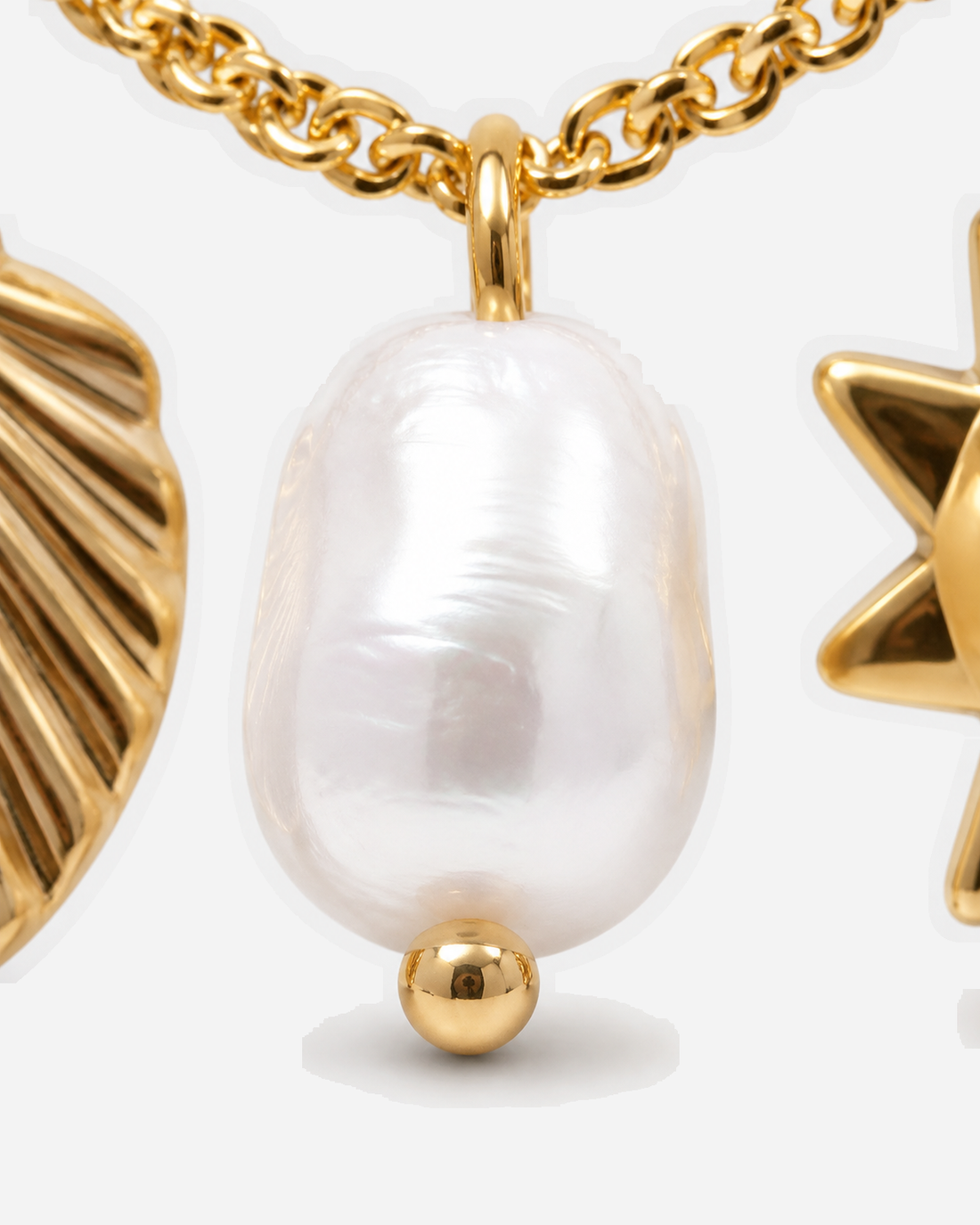 Lulwa irregular white pearl detail beside gold-tone shell and sun charm edges
