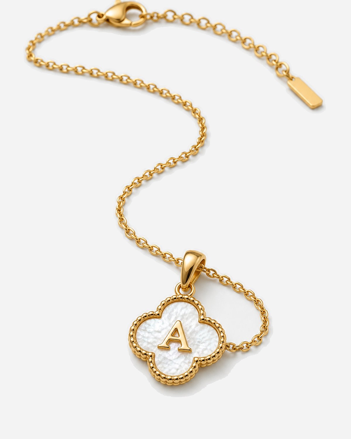 Gold Clover Initial Necklace styled on ivory linen