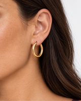 Model wearing one visible gold Vienna Classic Hoop Earring