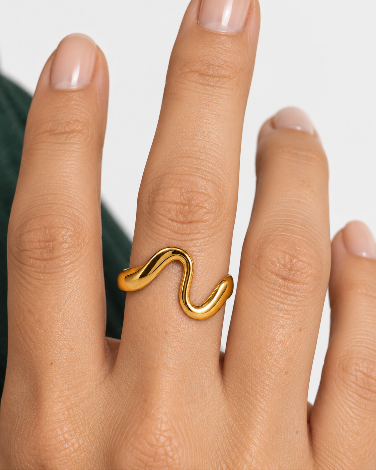 Talia gold-tone wave-shaped ring shown in a close hand wearing view