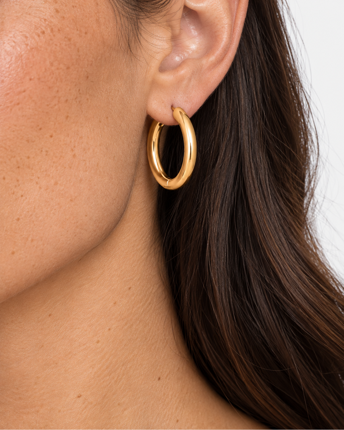 Close-up of one gold Vienna Classic Hoop Earring worn