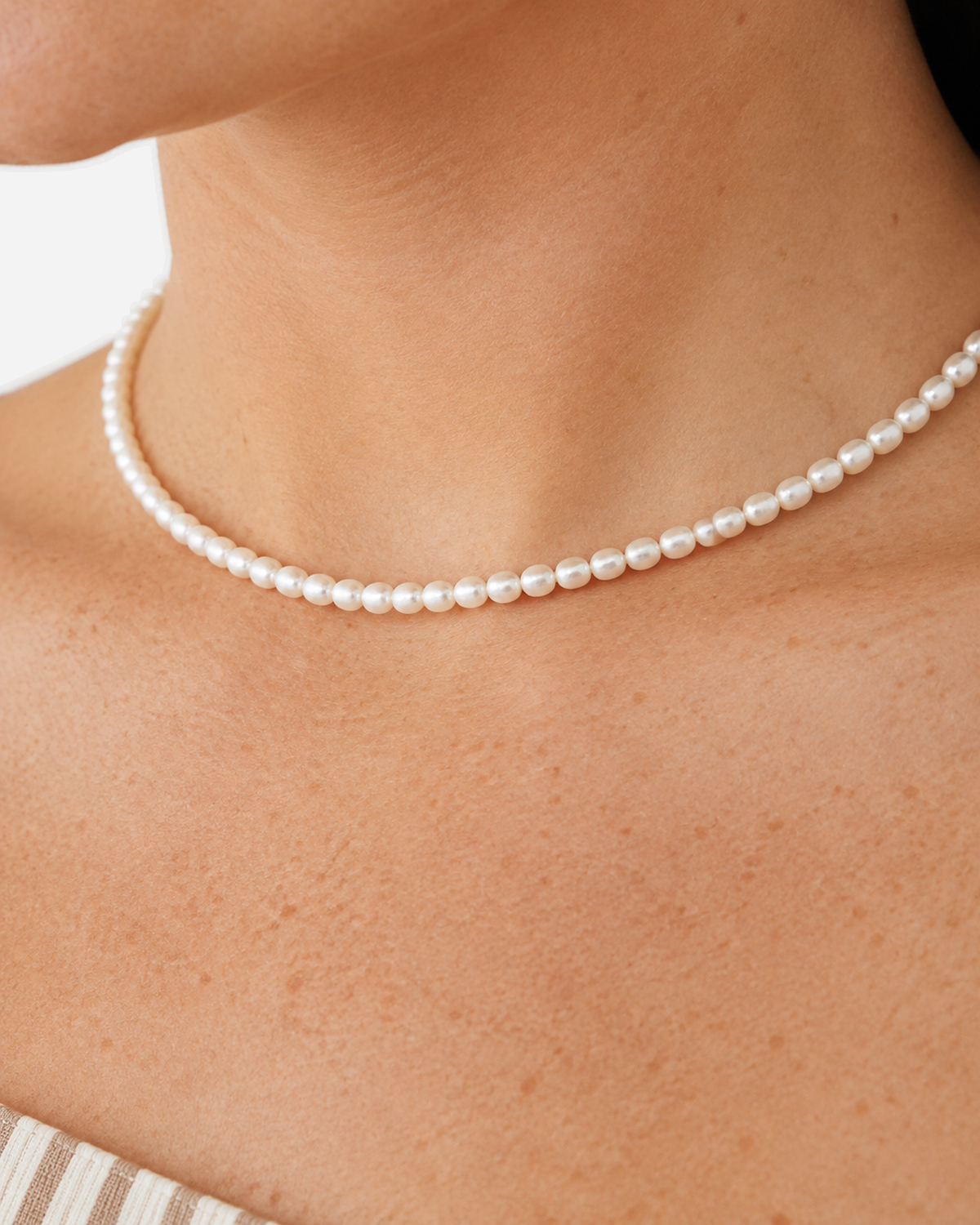 Elara Freshwater Pearl Choker — 09 — Gold — dusty-plum/taupe outfit — extreme on-body pearl macro
