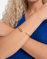 Janeva Adjustable Solid Bangle — crossed-forearm wearing view