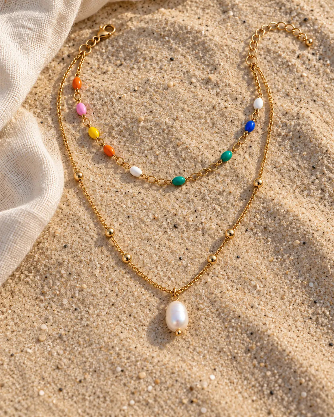 Akoya Layered Pearl Necklace with colourful stations and a pearl pendant on natural beach sand